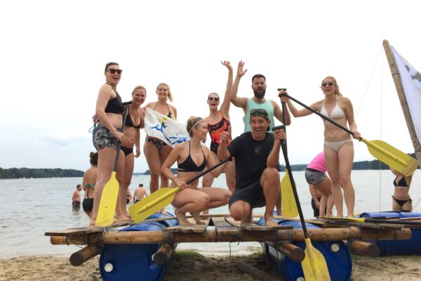 Zurück am Strand feiert ein Team die erfolgreiche Jungfernfahrt des selbstgebauten Floß.