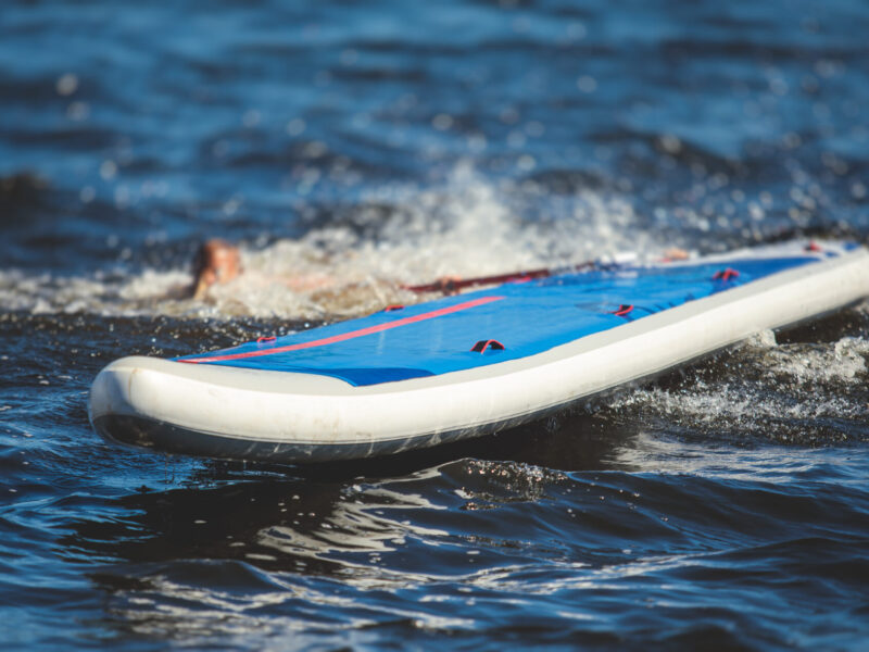 SUP-Surfer fällt beim SUP Polo vom SUP-Stand-Up-Paddle-Board.