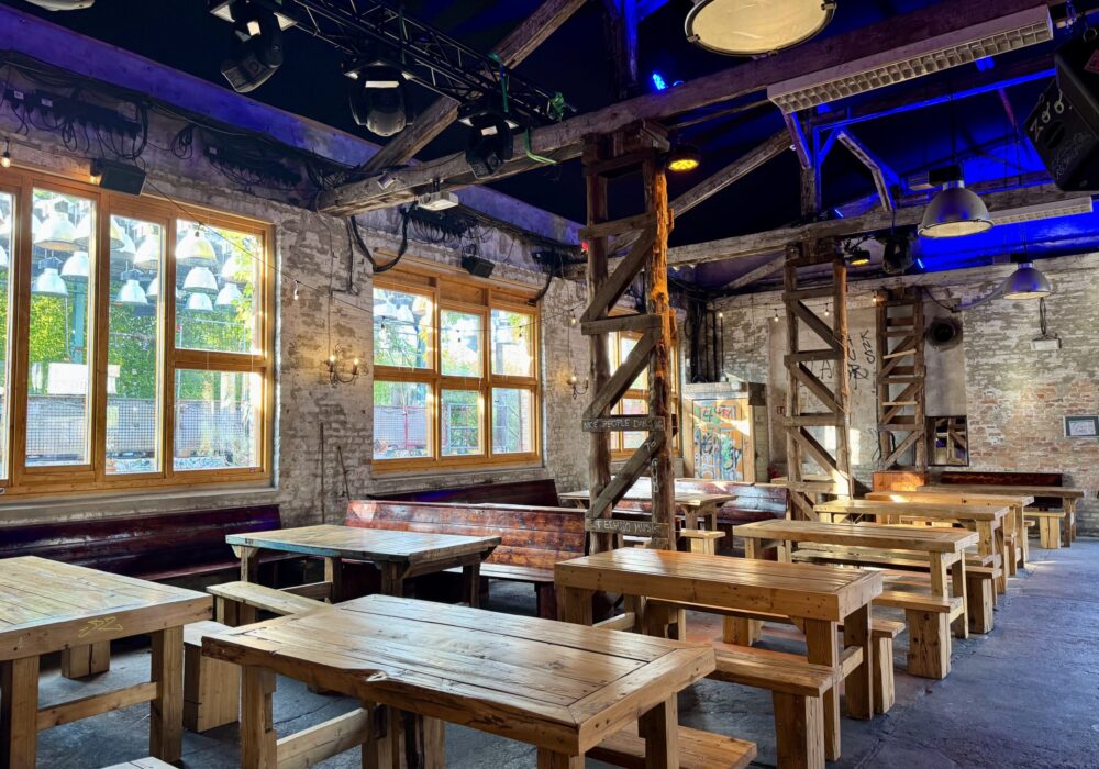 Ein weiterer Sitzbereich im rustikalen Innenbereich in der Location Revier Südost mit vielen Holztischen und Stühlen.