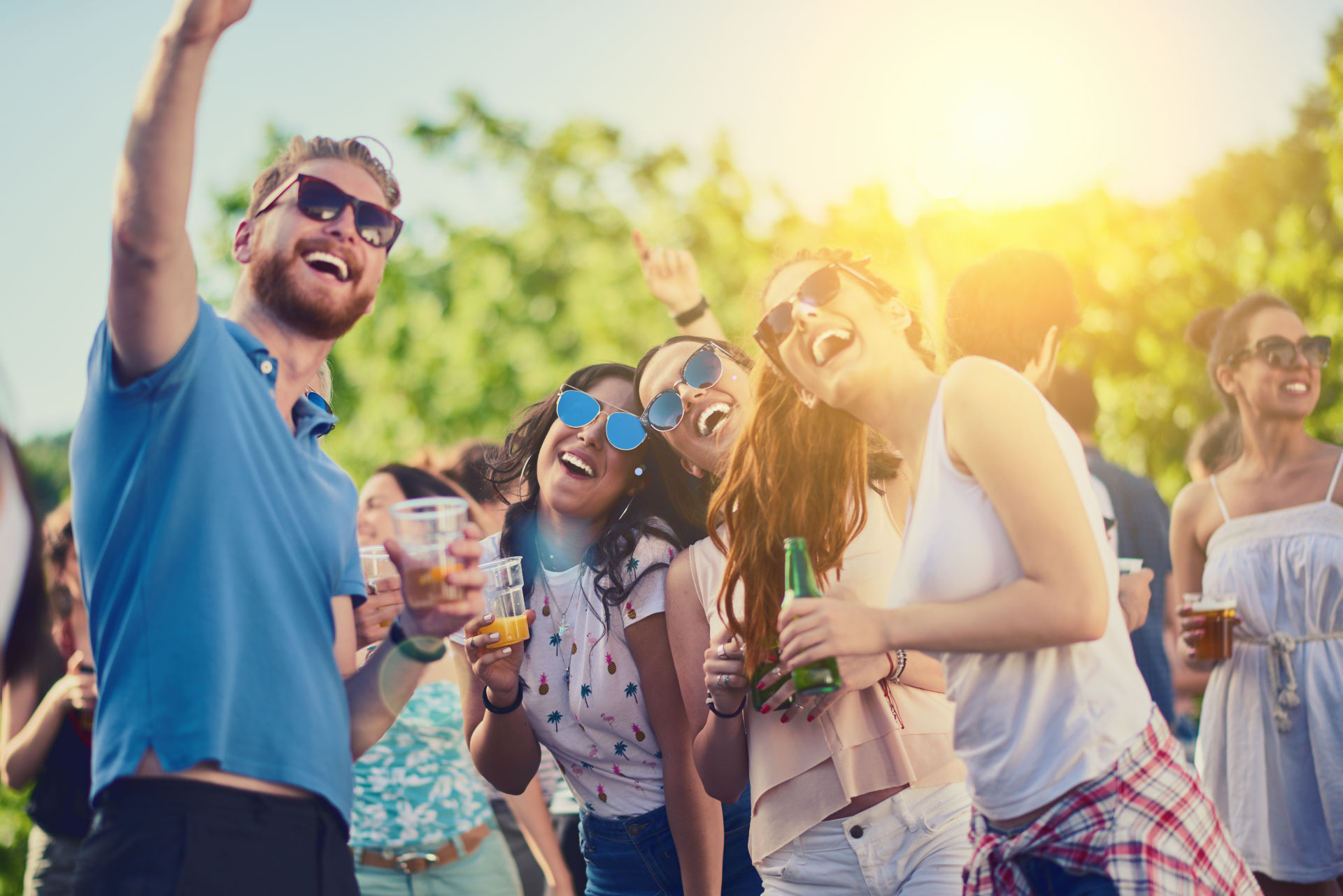 Einige Personen machen bei einem Sommerfest ein Selfie.