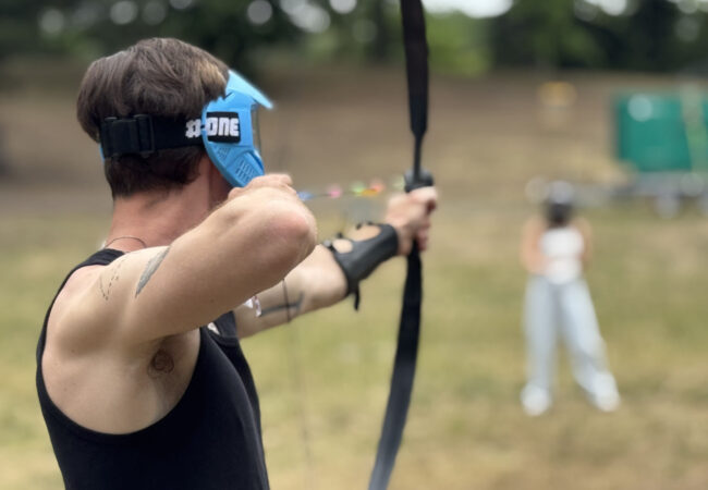 Person beim Arrow Tag mit Pfeil und Bogen im Strandbad Plötzensee in Berlin